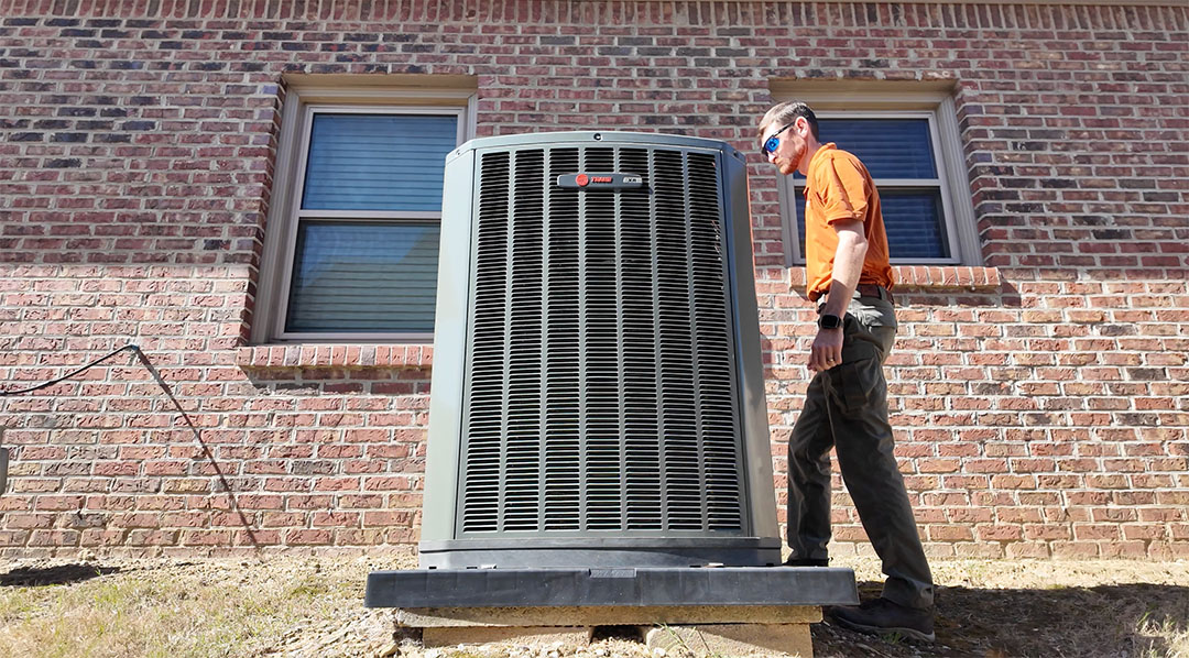 Skelton’s Technician Servicing Trane AC Unit in Birmingham AL Skelton’s HVAC technician inspecting a Trane outdoor air conditioner in Birmingham Alabama